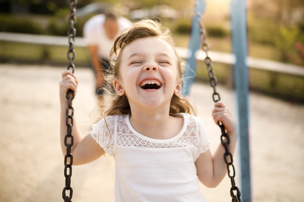 Picture of a child laughing on a swing