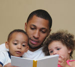 Picture of father reading to two young children