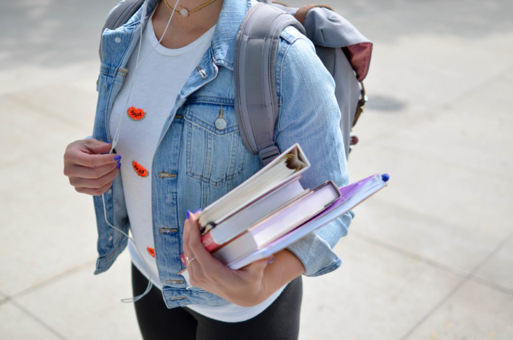 Cropped picture of young person with books in hand