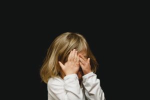 Picture of young child with hands covering eyes